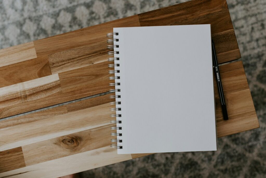 Switching Holiday Rental Managers: What Happens to Existing Bookings? 1 White spiral notebook on a wooden table; illustrative planning photograph